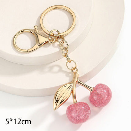 Tiny bubble pink cherry keyring decorated with golden leaves, creating light refreshing cheerful atmosphere all around