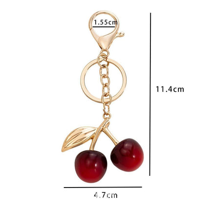 Compact red cherry bag charm with single gold leaf, gentle warm sweetness stays by your side anytime