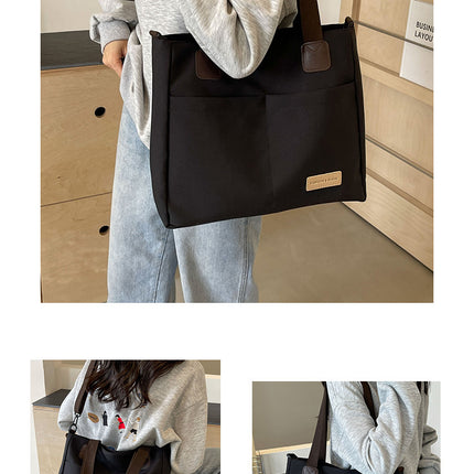 Stylish black canvas tote bag with detachable shoulder strap