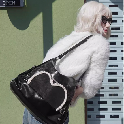 Stylish black tote backpack with heart embellishment - can be worn on one shoulder or as a backpack